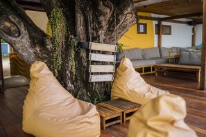 A tree with a wooden bench and a sign with text. - Tamarina Bed and Beyond (Koh Samui)