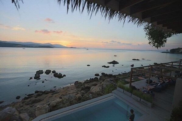 A pool area with a view of the sea and distant mountains during sunset. - Tamarina Bed and Beyond (Koh Samui)