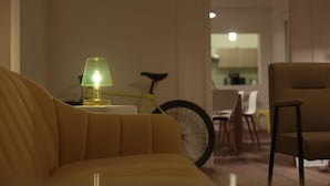 Una sala de estar moderna con un sofá, una lámpara y una bicicleta al fondo.