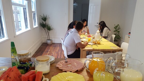 Un desayuno con una mesa de madera, frutas variadas y bebidas.