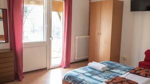 A bedroom with a bed, a wardrobe, a radiator, and a television. - Ca' Concordia Venice (Mestre)
