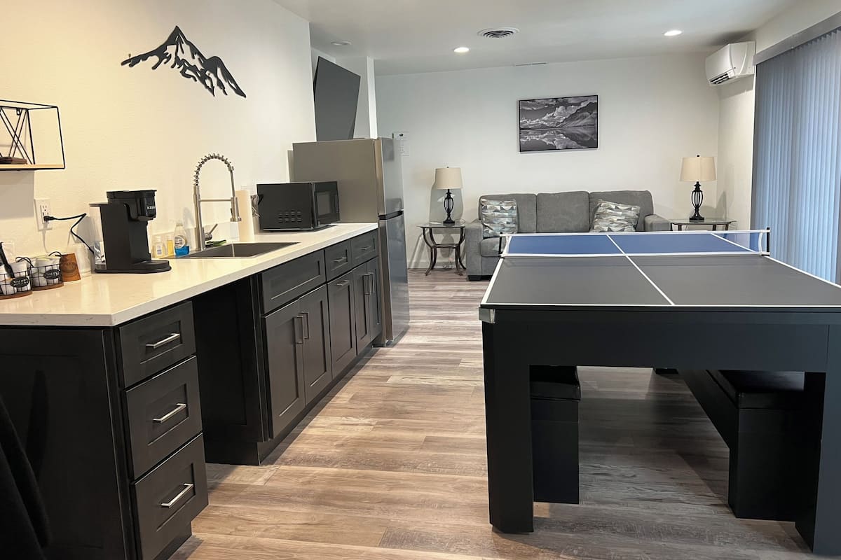 Una cocina moderna con mesa de ping pong, sofá y decoración montañesa.