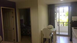 Ein kompakter Wohnbereich mit Essplatz, einer Küchenzeile und einem Schlafzimmer.