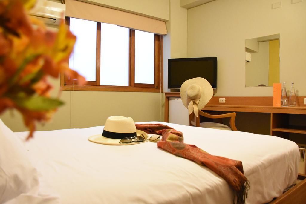 Une chambre d’hôtel équipée d’un lit, d’une télévision, d’un bureau et d’un miroir.