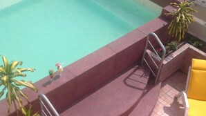 A swimming pool with steps leading into it, surrounded by potted plants and yellow lounge chairs. - Hotel Paraiso Trujillo (Trujillo)