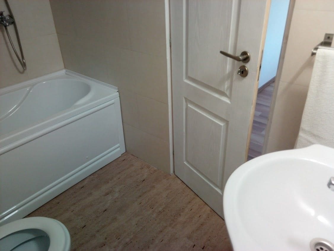 A bathroom with a bathtub, toilet, and sink.