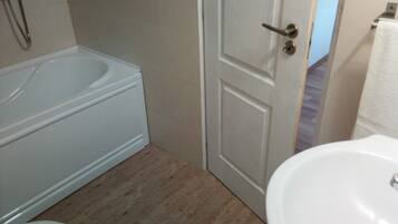A bathroom with a bathtub, toilet, and sink.