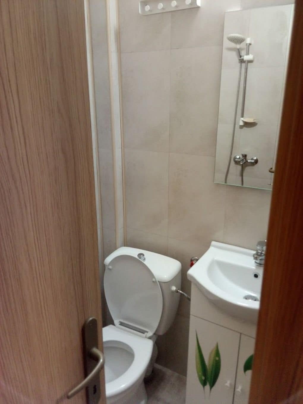 Un baño pequeño con inodoro, lavamanos y ducha.