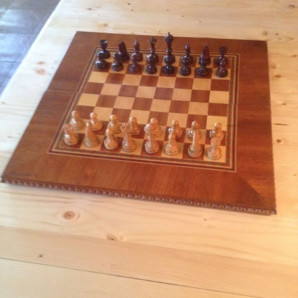 Un échiquier en bois avec les pièces disposées pour une partie.
