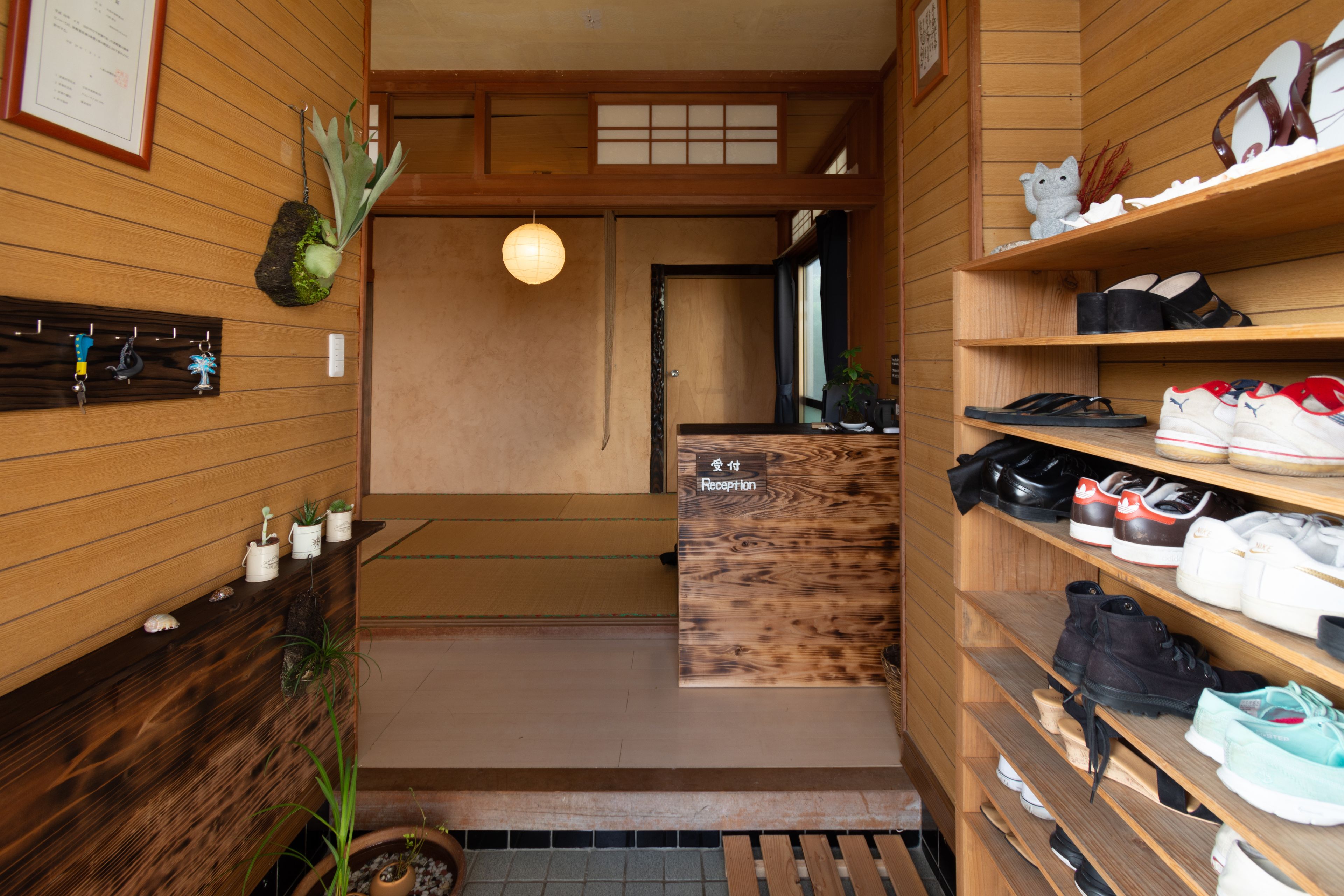 A reception area with wooden walls, a reception desk, and shelves with shoes.