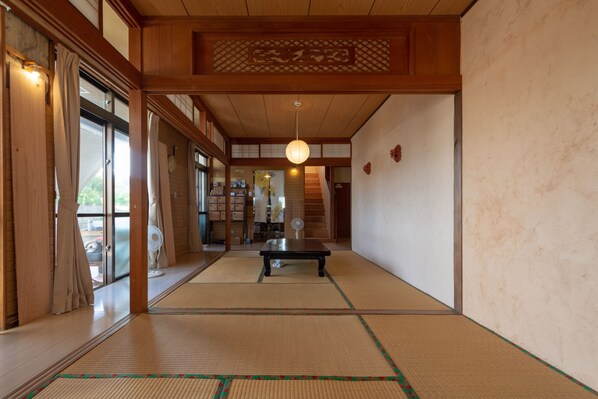 Una habitació japonesa tradicional amb sòls de tatami, una taula baixa i portes corredisses.