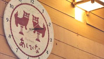 Un reloj de pared con diseño original que muestra dos gatos y caracteres japoneses.
