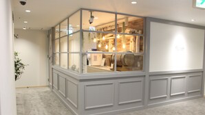 A room with a large window, a carpeted floor, and a white wall with a sign. - Executive Spa & Capsule WELLBE Fukuoka - Caters to Men (Fukuoka)