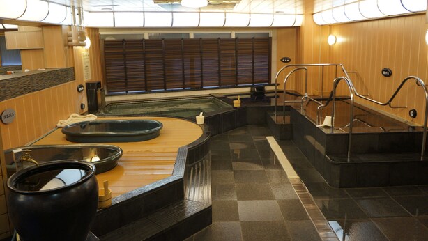 A sauna area with a wooden bench, a large black container, and a small white container. - Executive Spa & Capsule WELLBE Fukuoka - Caters to Men (Fukuoka)