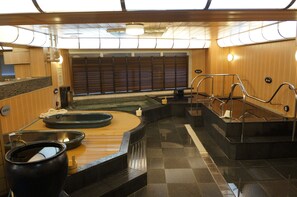 A sauna area with a wooden bench, a large black container, and a small white container. - Executive Spa & Capsule WELLBE Fukuoka - Caters to Men (Fukuoka)