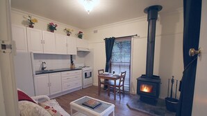 A cozy living room with a fireplace, white cabinets, and a dining area.
