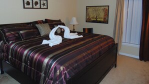 A hotel room with a bed, a ceiling fan, a window with curtains, and artwork on the walls. - Cozy/Spacious House with Private Pool and Lake View (Davenport)