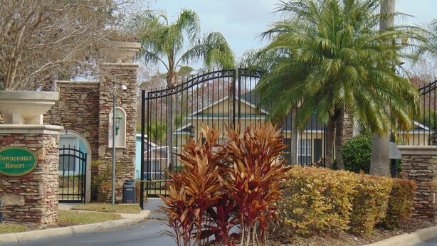 A gated entrance with a stone wall, a sign reading "Towncenter Resort," and a palm tree. - Cozy/Spacious House with Private Pool and Lake View (Davenport)