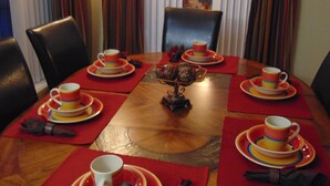 A dining table set with red placemats, white plates, and colorful cups. - Cozy/Spacious House with Private Pool and Lake View (Davenport)
