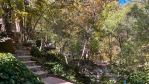 A stone staircase leading up a hill, surrounded by lush greenery and trees.