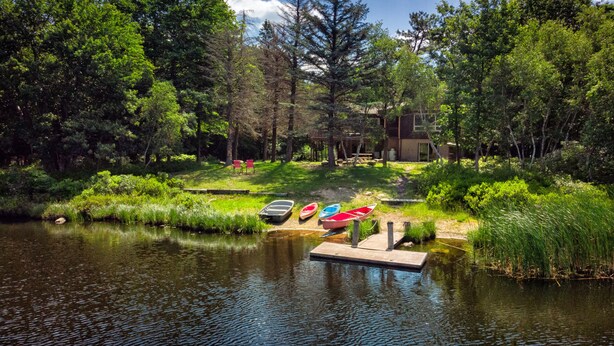 A serene lakeside setting with a dock and several boats. - Inn Kognito 1 Lakefront, hot tub fire pit Kalahari 2nd house next door available (Emerald Lake)