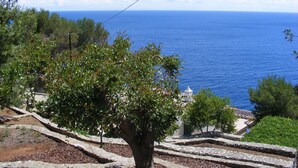Una escalera de piedra que conduce a un edificio blanco con cúpula, con vista al mar azul.