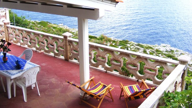 Una terraza con mesa y sillas, con vistas al mar.