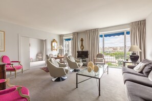A modern living room with a sofa, armchairs, a coffee table, and a TV. - Steps from the Eiffel Tower, by Veeve (Paris)