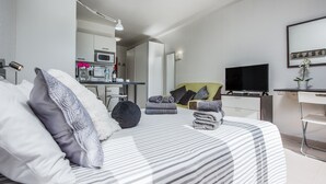A modern hotel room with a large bed, a desk with a flat-screen TV, a kitchenette, and a bathroom visible in the background. - Relax Forever with beautiful montain view Studio ¨A¨ (Puerto de la Cruz)