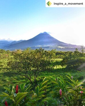 A landscape with a mountain in the background and lush greenery in the foreground. - Bosque Alto House (La Fortuna)