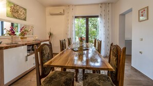 A dining area with a wooden table, chairs, and a kitchen counter with cabinets and a sink.