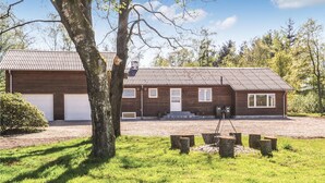 Et toetagers træhus med garage, veranda og indkørsel.