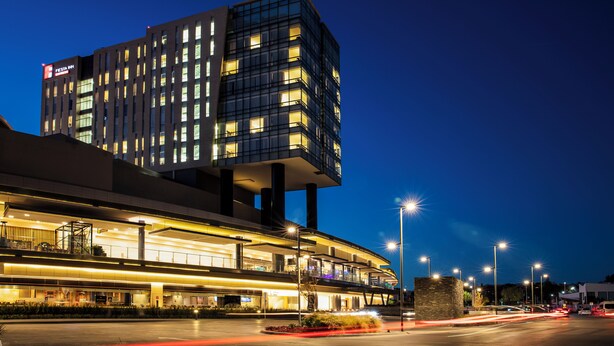 A modern hotel with multiple floors, a prominent signage, and a well-lit entrance area. - Fiesta Inn Express Queretaro Constituyentes (Querétaro)