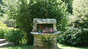 A stone bench with a flower pot in a garden. - Concarneau, Former Mill of Kérangoc, in the countryside, near the ocean, Wifi (Melgven)