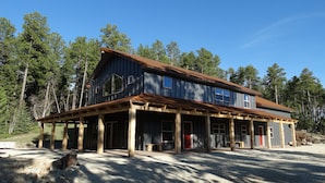 A two-story wooden cabin with a porch, surrounded by trees. - Home away from Home , just minutes from Deadwood. (Deadwood)