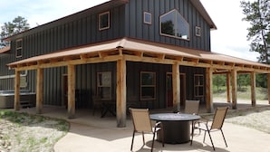 A two-story building with a covered patio area featuring a fire pit and outdoor seating. - Home away from Home , just minutes from Deadwood. (Deadwood)
