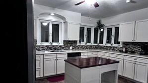A kitchen with white cabinets, a marble countertop, a ceiling fan, and a red rug. - Cozy family home, close to all things Hershey and Central Pennsylvania... (Palmyra)