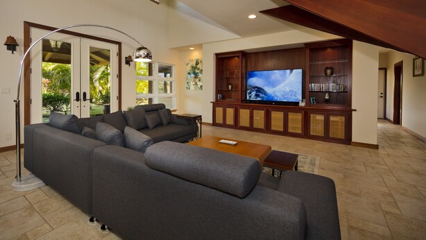 Una sala de estar moderna con un sofá modular, un televisor de pantalla plana y un mueble de madera para entretenimiento.