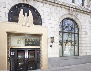 The Lincoln Building entrance with a large eagle emblem above the doors and a sign indicating the building's name.