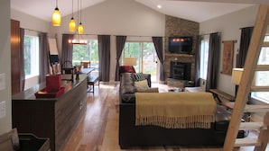 A modern living space with a kitchen, dining area, and a fireplace. - Custom home in St Mary’s Glacier (Idaho Springs)