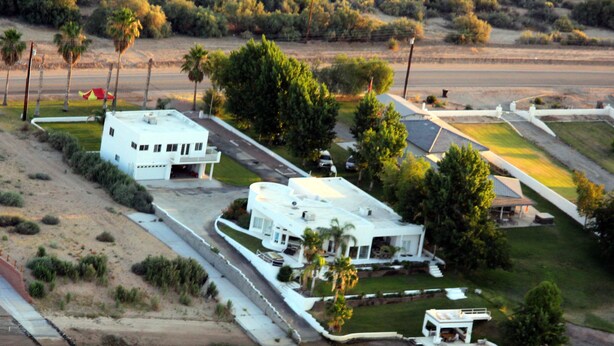 An aerial view of a residential area with a large white house, a dock, and a small boat. - River Front guest house with Ramp, Beach, Volleyball, and Gazebo on the Water (Big River)