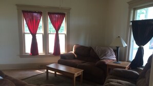 A living room with a brown sofa, a wooden coffee table, and a lamp on a side table.