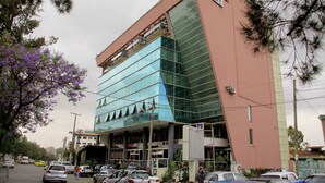 Um edifício moderno com fachada de vidro e exterior rosa.