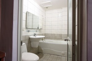 Un baño con inodoro, lavamanos y bañera.