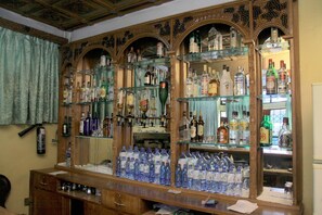 A bar area with shelves stocked with various liquor bottles and glasses. - Yonas Hotel (Addis Ababa)