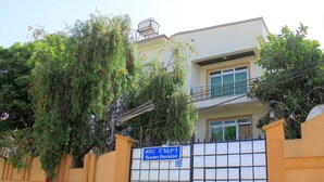 A two-story building with a gated entrance, a sign indicating it is a retirement home, and a balcony on the upper floor. - Tseder Pension (Addis Ababa)
