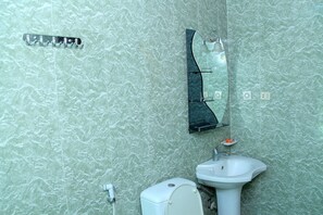 A bathroom with a toilet, sink, and a wall-mounted mirror.