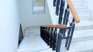 A marble staircase with black railings and wooden handrails. - Tseder Pension (Addis Ababa)