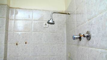 A bathroom with a shower, tiled walls, and a visible electrical outlet.