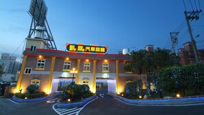 A hotel with a prominent sign, a well-lit entrance, and a parking area. - Cai-Lai Hotel (Taoyuan City)